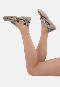 Wedge mules met een slangenprint patroon in beige en zwart. Gemaakt van soepel synthetisch materiaal met een gevoerde zool voor comfort.