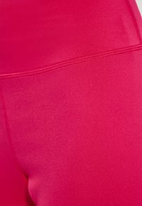 Leggings aderenti e elasticizzati di un vivace colore rosa. Tessuto liscio con un alto punto vita e cuciture rinforzate per una maggiore durata.