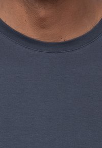 Marineblaue Rundhals-T-Shirt aus glattem Baumwollstoff, mit einer feinen Textur und verstärkter Nackennaht.