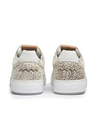 Sneakers bianchi con texture che presentano un motivo intrecciato, un tallone marrone e suola in gomma con marchio in rilievo sul lato.