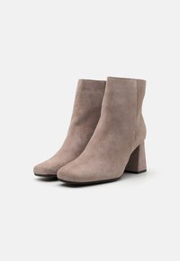 Šedé kotníkové boty z semiše se čtvercovou špičkou a masivním podpatkem. Hladká textura s minimálními švy.