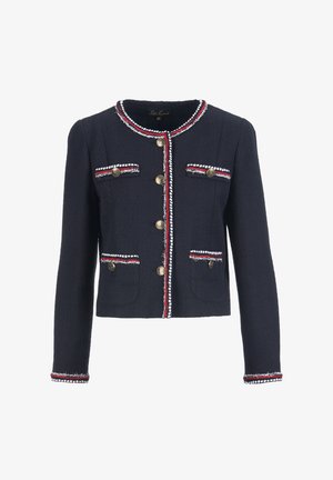 Navy zila tweed jaka ar zelta pogām, sarkanu un baltu apmali, divām priekšējām kabatām un apkakli ar saru galiem. Pielāgots siluets ar garām piedurknēm.