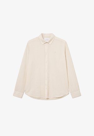 Krémová dlhá košeľa na gombíky s textúrovanou tkaninou, špicatým golierom a zaobleným spodným okrajom. Obsahuje jemné logo na hrudi.