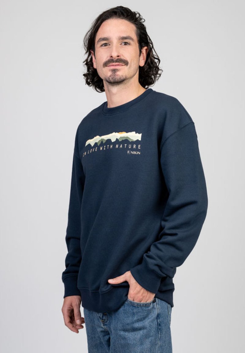 Navyblauwe sweatshirt gemaakt van een katoenmix, met een grafische afbeelding van een bergketen en de tekst "IK BEN VERLIEFD OP DE NATUUR" op de voorkant.