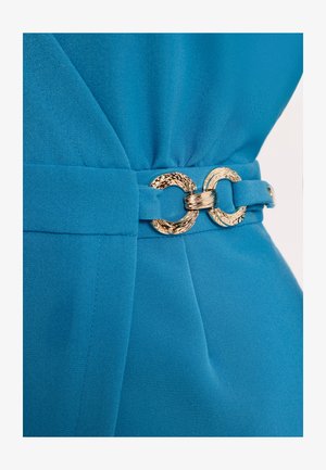 Niebieski pas materiałowy z teksturowaną złotą klamrą w kształcie podwójnego pierścienia, zapięty wokół talii ubrania.