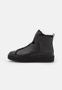 Botas de tobillo de cuero negro con un acabado texturizado, que presentan un cuello suave, paneles laterales elásticos y una suela de goma estriada para mayor agarre.