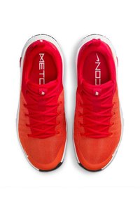 Rode sportschoenen met een gestructureerde mesh bovenkant die overgaat van helderrood naar donkerder rood, met witte accenten, een veter-sluiting en een zwarte buitenzool.