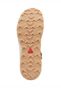 Suola in gomma color tan con tacchetti di trazione multidirezionali e un accento triangolare rosso, progettata per garantire stabilità e grip su diverse superfici.