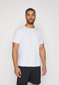 Camiseta deportiva de manga corta blanca, hecha de un tejido transpirable, con un cuello redondo y un discreto detalle del logo en la parte superior izquierda.