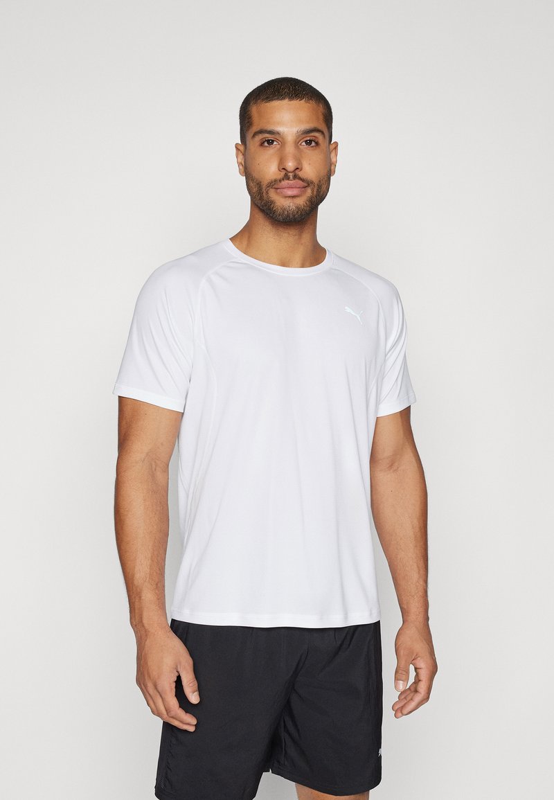 Camiseta deportiva de manga corta blanca, hecha de un tejido transpirable, con un cuello redondo y un discreto detalle del logo en la parte superior izquierda.