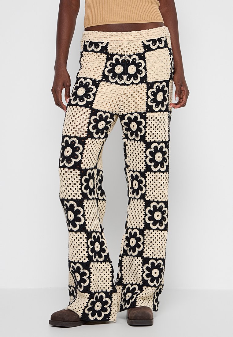 Häkelhosen in Beige und Schwarz mit floralem Muster, im weit geschnittenen Design und mit elastischem Bund. Strukturierter, bequemer Stoff.