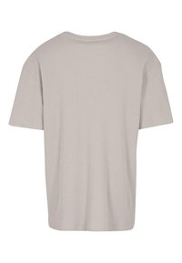 Tricou scurt cu mânecă scurtă de culoare bej deschis, cu un design texturat cu nervuri, croială confortabilă și decolteu rotund. Vederea din spate nu prezintă branding vizibil.