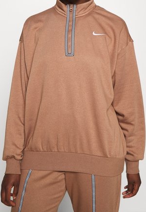 Brązowy, teksturowany sweter z wysokim kołnierzem i zamkiem błyskawicznym, z czarno-białym wzorem na akcentującej taśmie przy zamku. Logo Nike na piersi.
