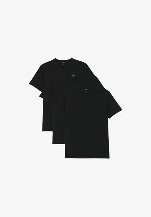 Trois t-shirts noirs unis à manches courtes et col rond, disposés en rangée légèrement superposée sur un fond blanc.