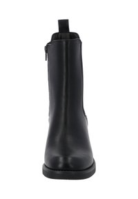 Bota de tobillo de cuero negro con un acabado suave, cremallera lateral y un lazo en el cuello. Punta redondeada y suela plana baja.