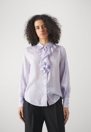 Světlá levandulová blůza s řaseným výstřihem, dlouhými rukávy s knoflíkovými manžetami a jemnými texturovanými vzory.