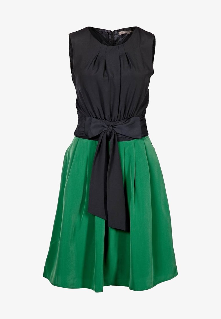 Robe sans manches avec un corsage noir ajusté et une jupe trapèze verte, ornée d'une ceinture à nœud à la taille et de plis subtils sur le corsage.