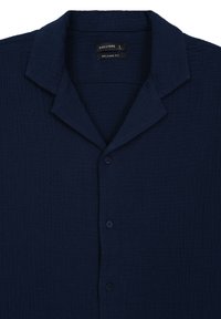 Camicia a maniche corte blu navy con vestibilità rilassata, materiale testurizzato, colletto e quattro bottoni sulla parte anteriore.