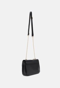 Bolso de mano de cuero negro con forma rectangular, que cuenta con un cierre de solapa y un diseño texturizado. Cadena y correa desmontable de cuero.