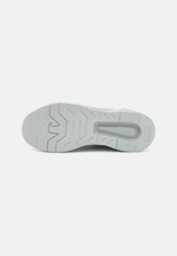 Grey sneaker sole with textured rubber, featuring traction patterns and a raised emblem. Smooth surface with reinforced edges.