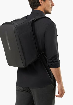 Black backpack with a rectangular shape, textured fabric, adjustable straps, and a side zipper. Logo visible on the front panel.