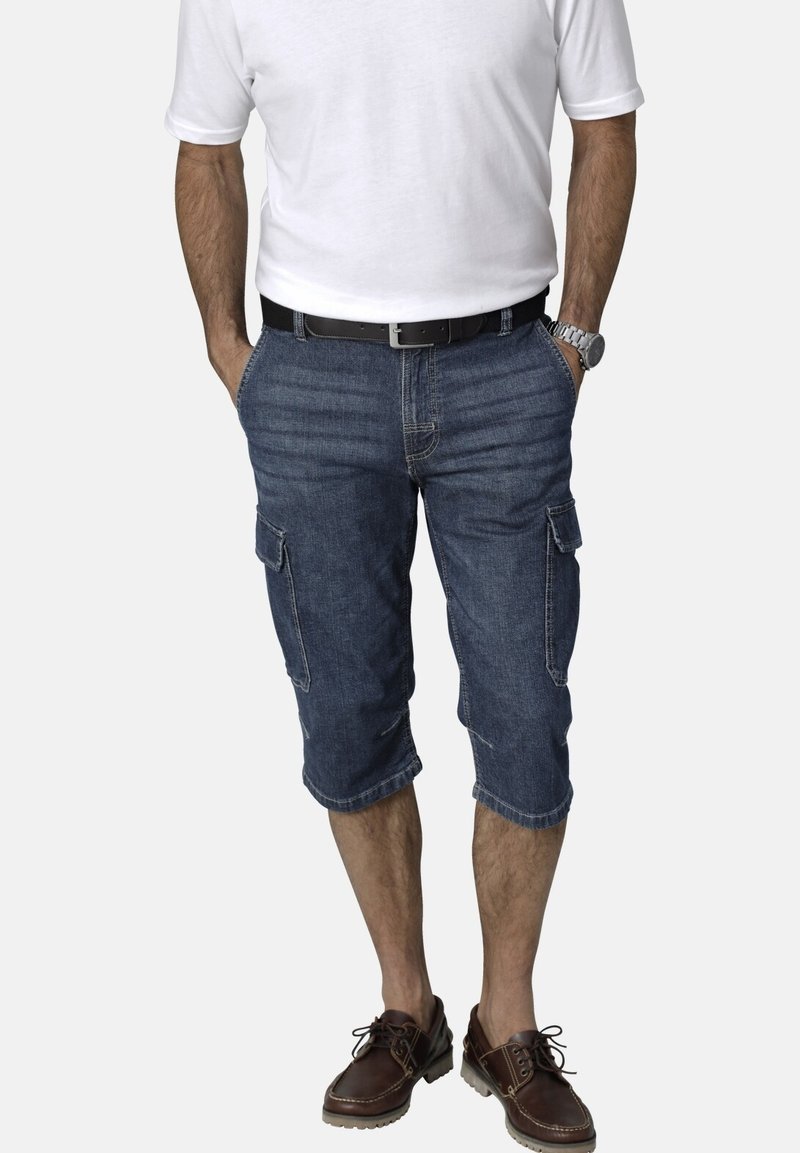 Denim cargo shorts with a relaxed fit, knee-length, featuring two side pockets, and a slightly distressed look. Paired with brown shoes.