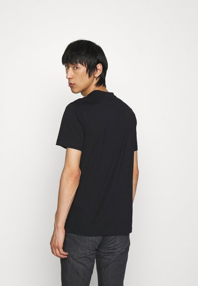 Black short-sleeve t-shirt with a round neckline, made of soft fabric. Featured on a model facing away, with neutral background.