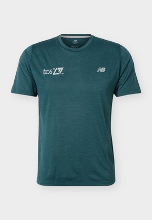 Tmavotealové športové tričko s krátkym rukávom a okrúhlym výstrihom, s bielymi nápismi „tcs New York City Marathon 2026“ a logami New Balance na hrudi.