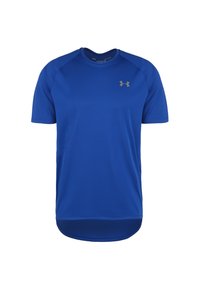 Camisa deportiva azul de manga corta hecha de tejido transpirable con cuello redondo, que presenta un dobladillo ligeramente curvado y un pequeño logo en el pecho.