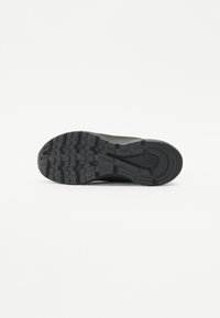 Black athletic shoe sole with textured pattern, featuring deep treads for traction and curved edges for support. Durable rubber material.