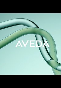 Logo Aveda affiché avec des tubes en verre entrelacés dans des dégradés de verts sur un fond bleu-vert clair, présentant des textures lisses et des bulles.