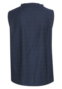 Ärmlös mörkblå topp med en texturerad tyg, som har en rund halsringning med subtila volangdetaljer längs kanten.