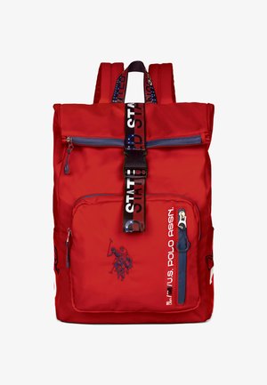 Punainen nailonreppu, jossa on pehmustetut olkahihnat, vetoketjullinen etutasku, logokoristeet ja kuvioitu hihna. Sileä pinta, suorakulmainen muoto.