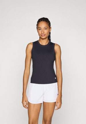 Svart ribbet tank-top med rund hals, parret med hvite shorts med logo. Stoffet ser lett og tettsittende ut.