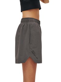 Sidebillede af person iført grå elastiske talje shorts med forlommer og sort tekst "HALO 1968 1972 1981" på venstre ben.