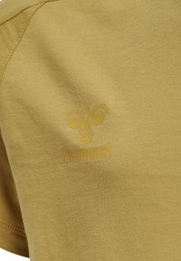 Gul bomulls-T-shirt med en mjuk textur, korta ärmar och en logotyp tryckt i en något mörkare gul nyans på framsidan.