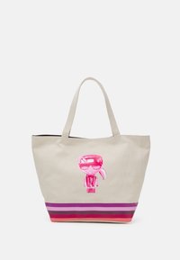 Beige canvas tote bag med en rosa tecknad figur grafik. Har horisontella ränder i lila, rosa och röd i botten.