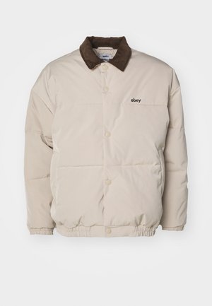Beige Daunenjacke mit braunem Cordkragen, Druckknöpfen und elastischem Saum. Mit Logo auf der Brust. Leicht gesteppte Textur.