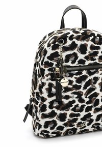 Zaino con stampa leopardata su sfondo in tela bianca, con macchie marroni e nere, hardware in argento e una tasca frontale con zip e frange decorative.