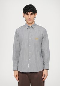 Srajca s pritiskači s sivimi in belimi črtami, z ovratnikom, dolgimi rokavi in majhnim logotipom na prsih. Teksturiran bombažni material.