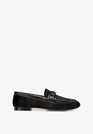 Zwarte leren en suède herenslipper met een lage hak en een banddetail over de wreef, in profiel weergegeven op een witte achtergrond.