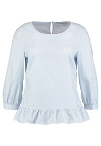 Blouse à rayures bleu clair avec un col rond, des manches trois-quarts et un ourlet volanté. Le tissu semble lisse et doux.