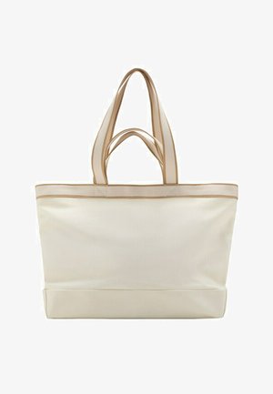 Elfenbeinfarbene Canvas-Tragetasche mit doppelten beigen Griffen und braunem Besatz entlang der oberen Kante, steht aufrecht vor weißem Hintergrund.