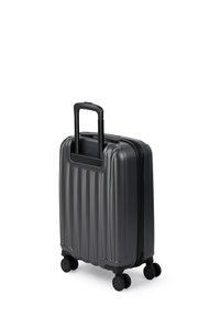 Kompaktowa czarna walizka twarda z czterema obrotowymi kółkami i wysuwaną rączką.