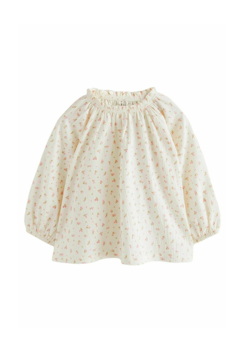 Helle Cremebluse mit kleinen rosa Blumenmustern, gerafftem elastischen Ausschnitt und puffigen Ärmeln. Hergestellt aus strukturiertem Stoff.