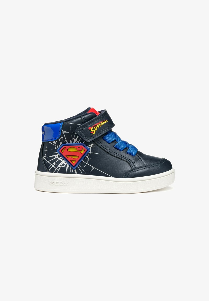 Zapatillas altas de cuero azul marino con acentos azules, presentan una correa de Velcro, cordones azules, suela blanca y el logo de Superman con un diseño gráfico.