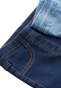 Deux paires de jeans : une paire bleu foncé et une paire bleu clair, avec des coutures contrastées et des poches arrière standard.