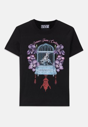Črna majica s pisanimi grafičnimi motivi ptičje kletke s ptico, obkroženo z orhidejami. Oblikovanje vključuje zapletene detajle in teksture.