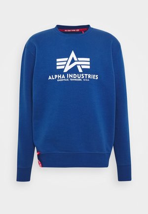 Blå crewneck-sweatshirt med hvidt Alpha Industries-logo og teksten "Knoxville, Tennessee, U.S.A." på forsiden, med ribstrikkede manchetter og kant.