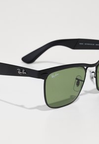 Ochelari de soare Ray-Ban negri cu lentile verzi, formă rectangulară, finisaj mat și logo argintiu pe braț. Padding-ul de nas este ajustabil.